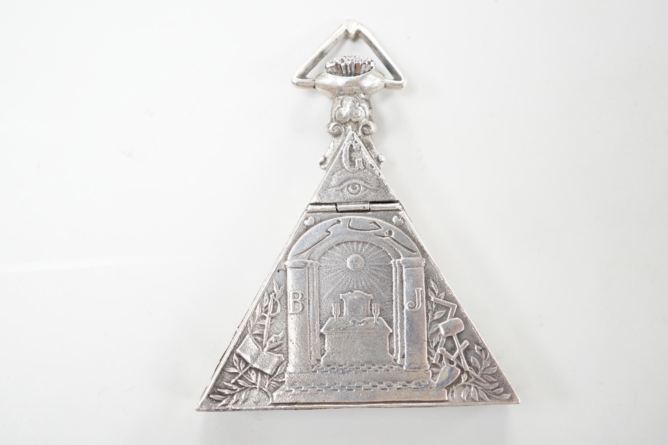 A 1920's Swiss 800 standard white metal triangular masonic pocket watch, by the Solvil Watch Co. set with cabochon garnet, the mother of pearl dial decorated with masonic symbols, width, 51mm.